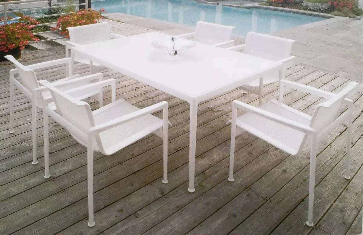 Knoll Studio 1966 Collection Essstuhl in Weiß auf einer Terrasse neben einem Pool mit sechs Stühlen und einem Tisch in einer entspannten Atmosphäre.