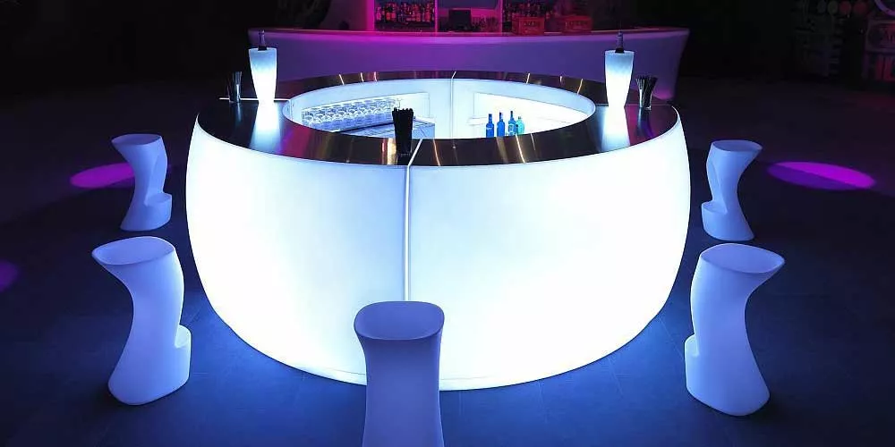 Vondom Fiesta Bargruppe in Weiß, beleuchtet, auf dunklem Boden in stimmungsvoller Nachtaufnahme.