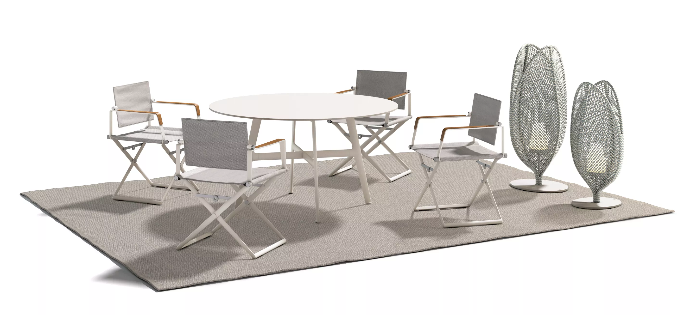 Dedon Seax Essgruppe mit vier Stühlen und rundem Tisch auf grauem Teppich im Freien mit zwei dekorativen Lampen im Hintergrund