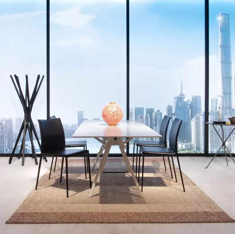 Esszimmer mit Zanotta 2086 Lia Stühlen und Tisch in modernem Ambiente mit Stadtblick und dekorativer Lampe auf dem Tisch.