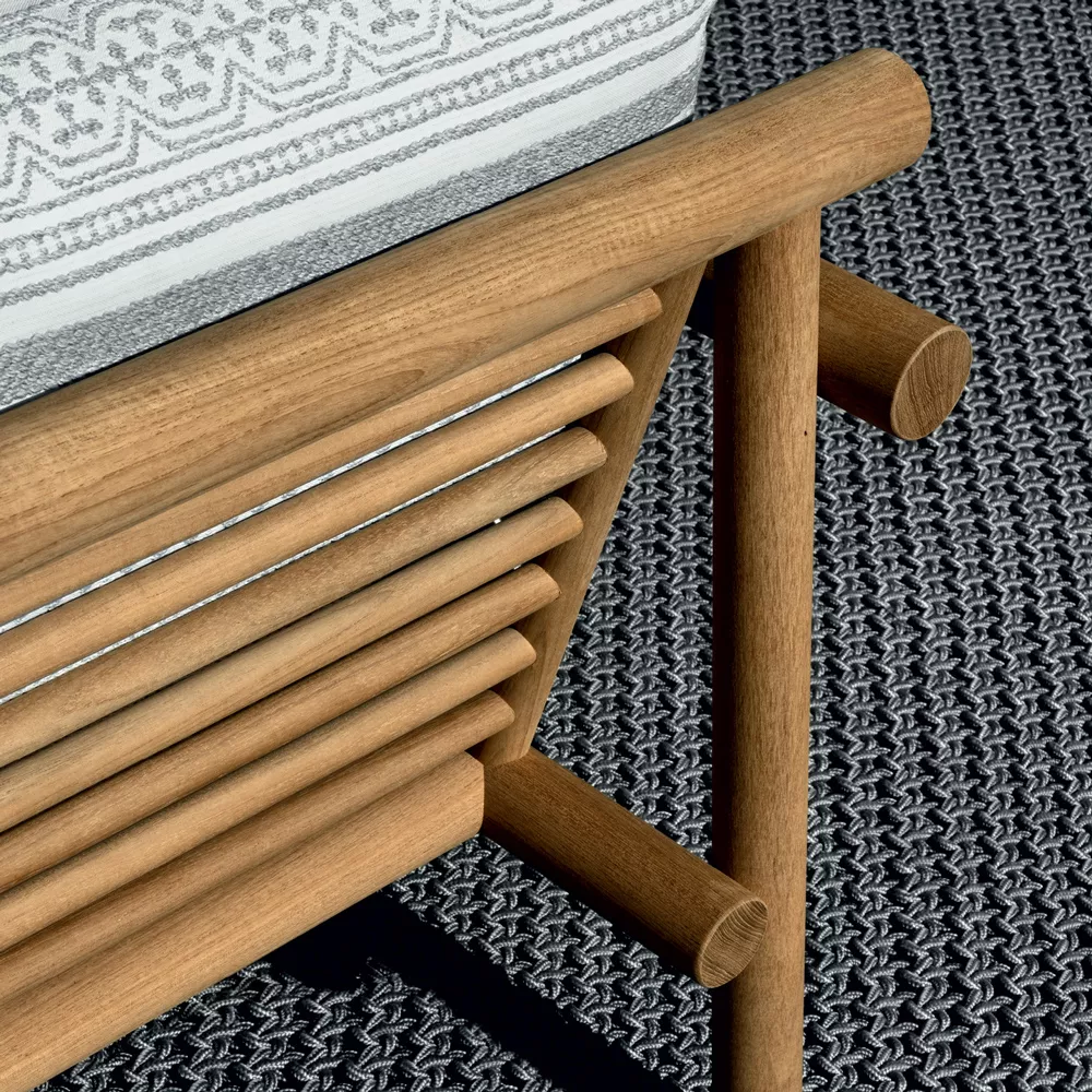 B&B Italia Ayana Gartensofa zeigt eine Detailaufnahme des Holzrahmens und des gemusterten Polsters auf einem strukturierten Teppich