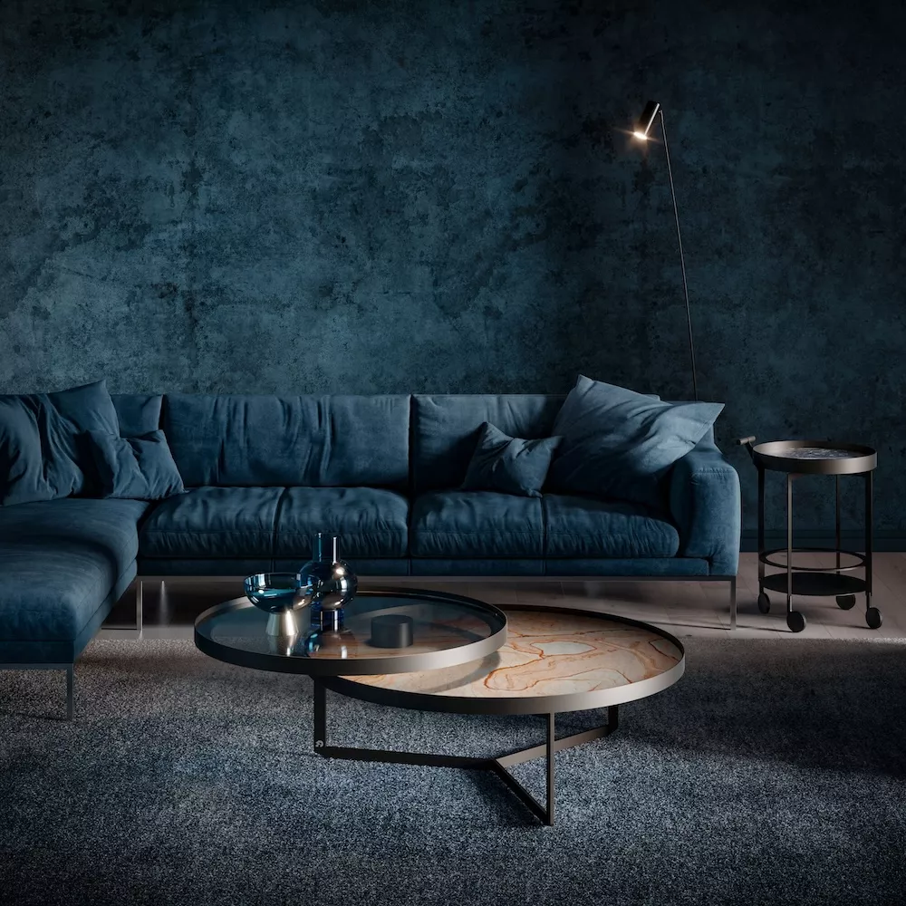 Draenert Nebra V Couchtisch in einem stilvollen Wohnzimmer mit blauer Couch und Stehlampe