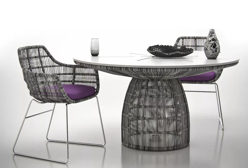 B&B Italia Crinoline Outdoor Gartenstuhl mit Polyethylenfasergeflecht und lila Kissen an einem runden Tisch mit Dekoration ohne Hintergrund