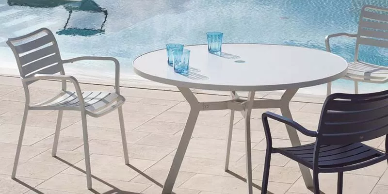 Ethimo Studios Outdoor-Essgruppe in Weiß und Dunkelblau, bestehend aus einem runden Tisch und Stühlen, auf einer Terrasse am Pool.