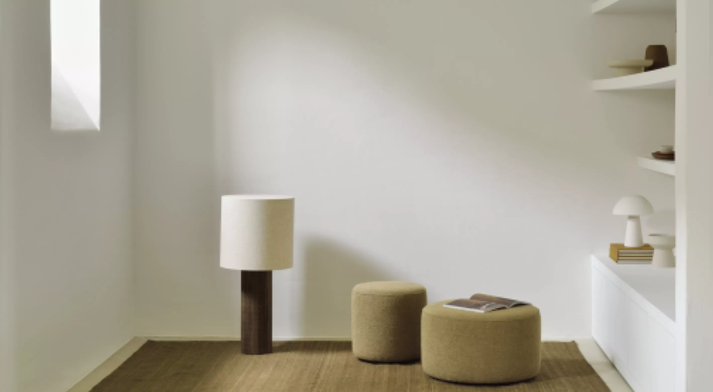 Beige Sitzhocker und Stehlampe in modernem, minimalistischem Wohnzimmer mit weißem Hintergrund und natürlichem Licht.