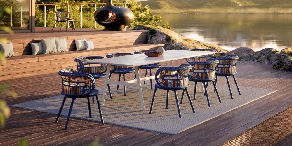 DEDON Cirql Stühle und Tisch auf einer Terrasse mit Seeblick und Bergen im Hintergrund