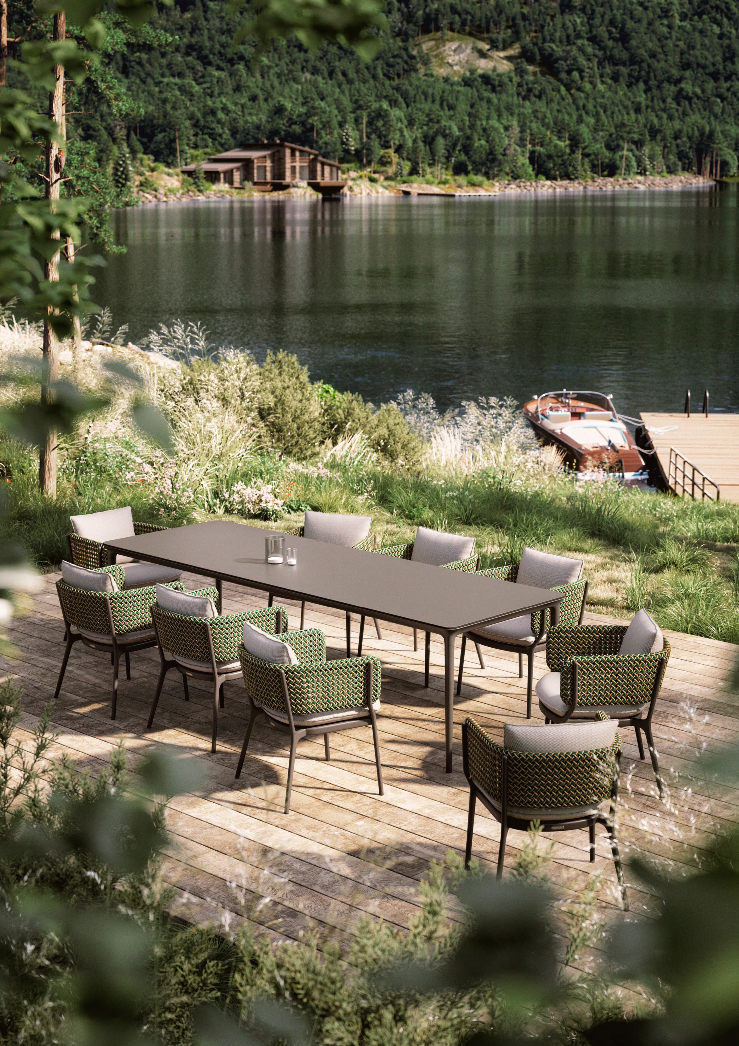 DEDON BELLMONDE Esstisch und Stühle auf einer Terrasse mit Blick auf einen See und bewaldete Hügel im Hintergrund