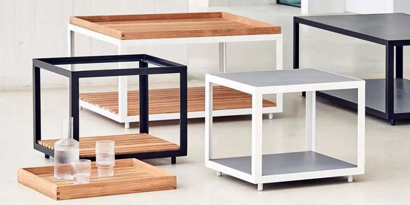 Cane Level Beistelltische in Schwarz und Weiß, aus Holz und Metall, auf hellem Boden in modernem Ambiente.