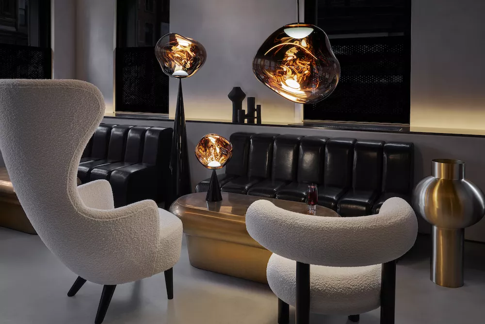 Stimmungsbild mit Tom Dixon MELT Pendelleuchte, Tisch- und Stehlampe in warmem Bernstein, in modernem Lounge-Interieur.