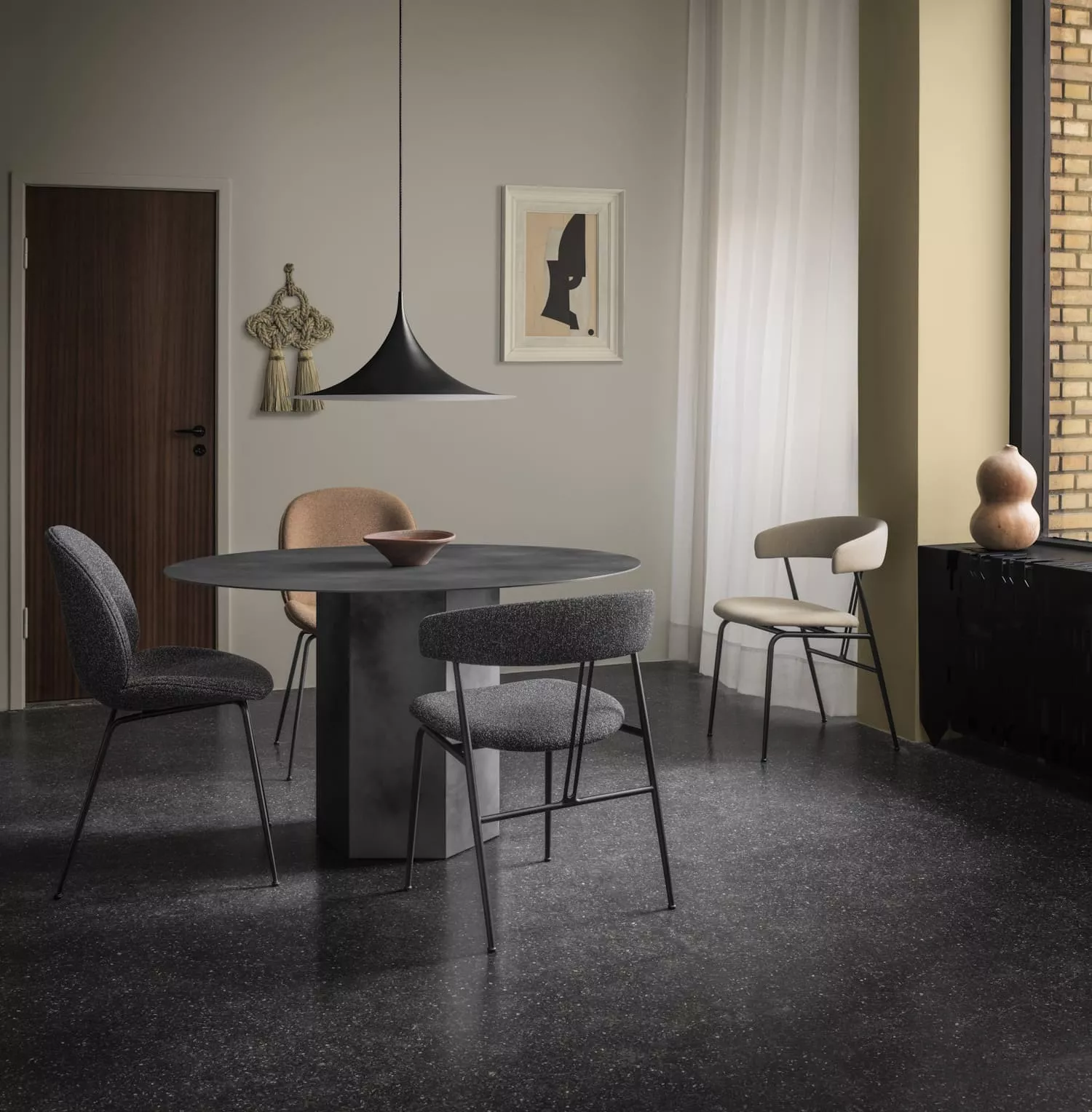 Gubi Epic Violin SemiPendant hängt über einem modernen Esstisch mit vier Stühlen in einem stilvoll eingerichteten Raum mit Kunst an der Wand