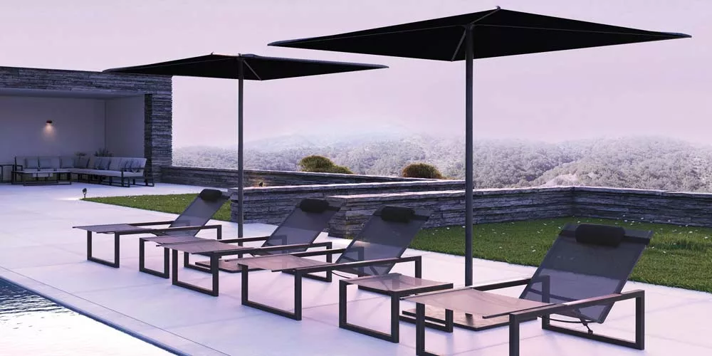 Royal Botania Blum Sonnenschirme in Schwarz über modernen Liegestühlen auf einer Terrasse mit Pool und Garten im Hintergrund.