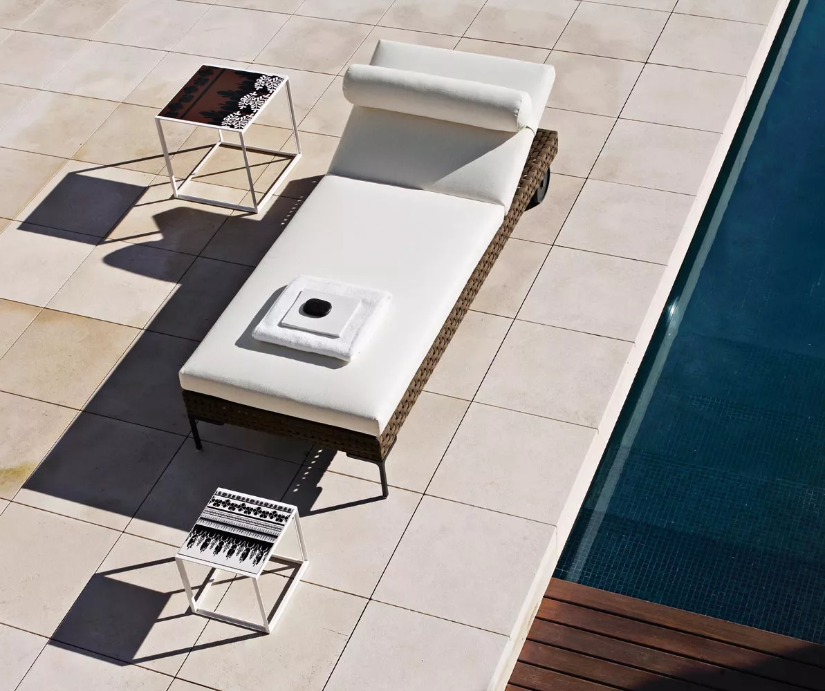 Charles Outdoor von B&B Italia Sonnenliege in weiß auf einer Terrasse neben einem Pool mit zwei Beistelltischen und einem Handtuch