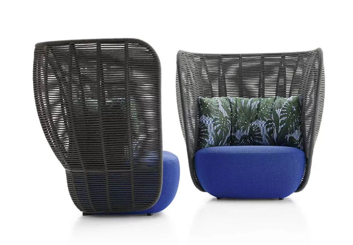 Der B&B Italia Bay Loungesessel mit hoher Rückenlehne in Blau und geflochtenem Design steht in einem modernen Ambiente.