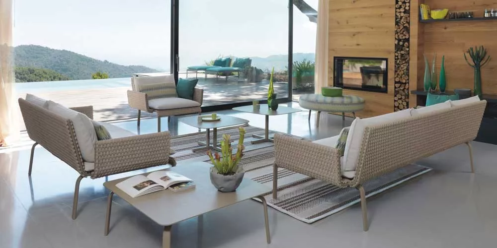 Gartenmöbel-Set Roberti Key West in Beige auf Terrasse mit Bergblick, bestehend aus Sofas, Sesseln und Tisch, moderne Atmosphäre.