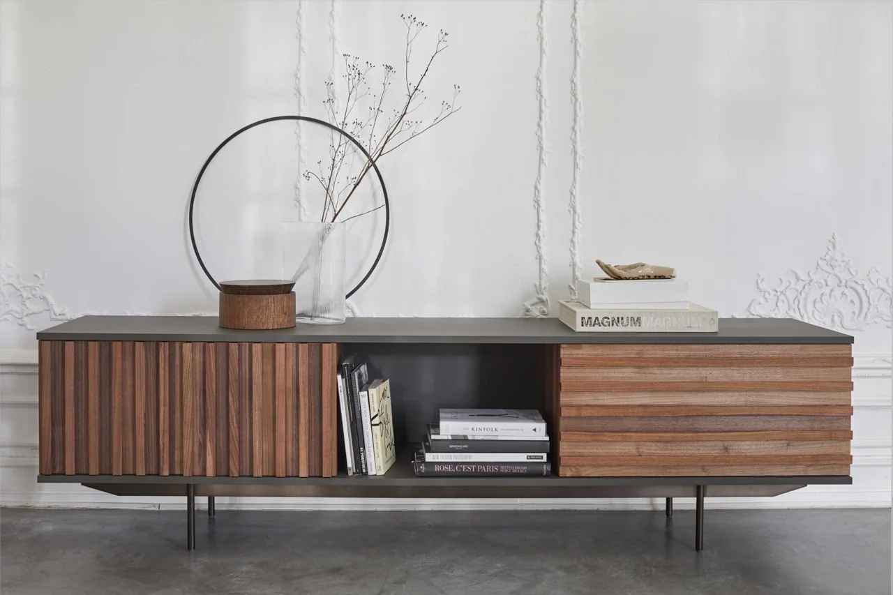 Villa Schmidt HARRI Sideboard in Braun und Schwarz, groß, vor weißer Wand mit Dekoration, Bücher und Vase, auf Betonboden.