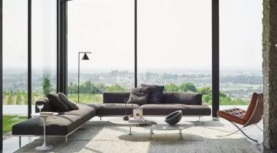 Knoll Matic Sofa in modern Wohnzimmer mit Panoramafenster und Blick auf die Landschaft mit Beistelltisch Lampe und Sessel im Hintergrund