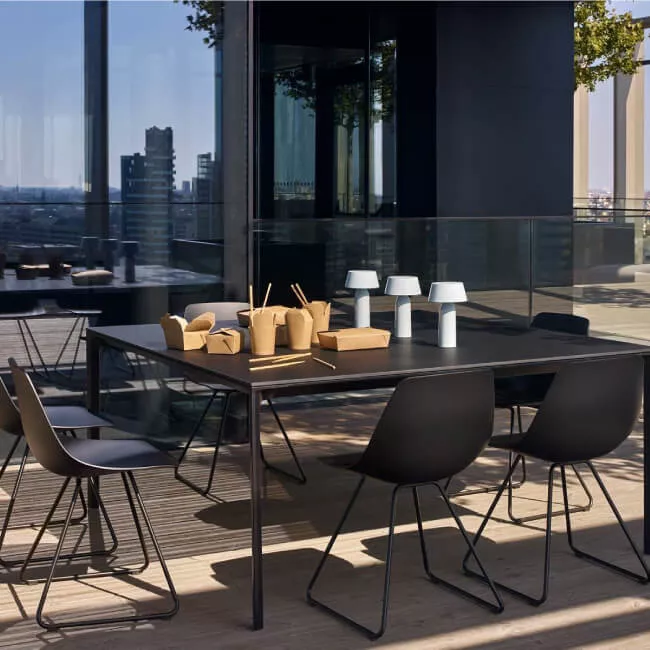 Schwarzer Barstuhl Miunn 65 cm von Lapalma auf einer modernen Terrasse mit Glasgeländer und Stadtblick im Hintergrund.
