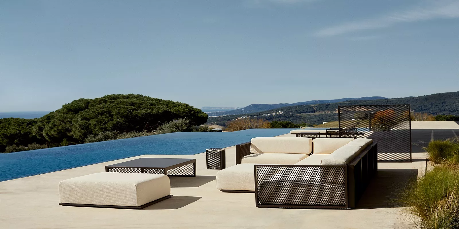 Die Vondom The Factory Collection von Ramon Esteve in Beige und Schwarz auf einer Terrasse mit Blick auf das Meer.