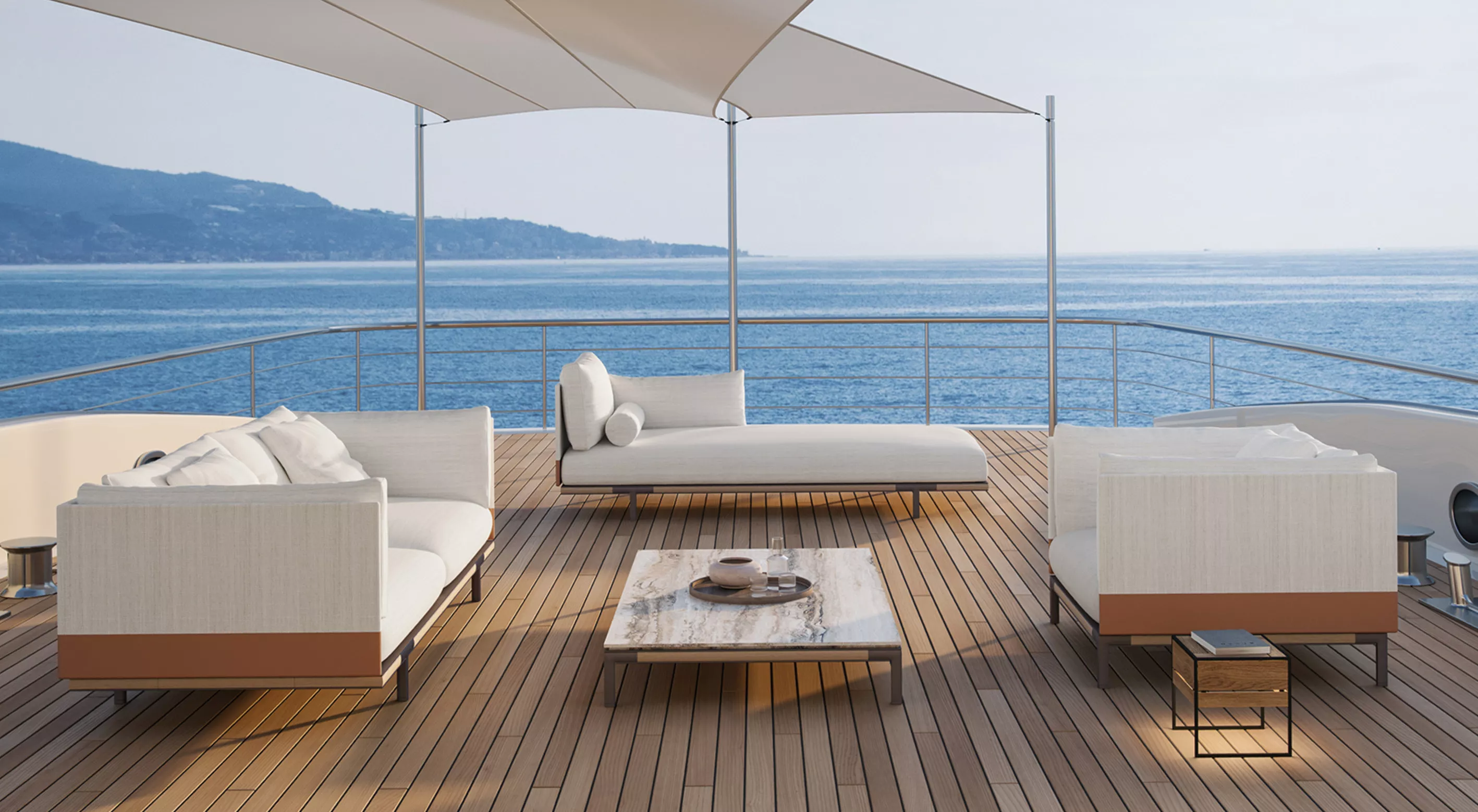 Sicht auf eine stilvolle Outdoor-Lounge mit Minotti Sofas in Weiß auf einer Yacht, umgeben von Meer und Himmel, bei sonnigem Wetter.