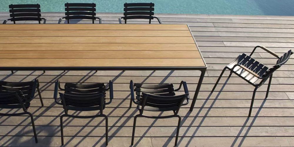 Houe Kollektion Four, schwarzer Metallrahmen mit Holzplatte, Gartenmöbel-Set am Pool auf Holzterrasse, stimmungsvolles Ambiente.