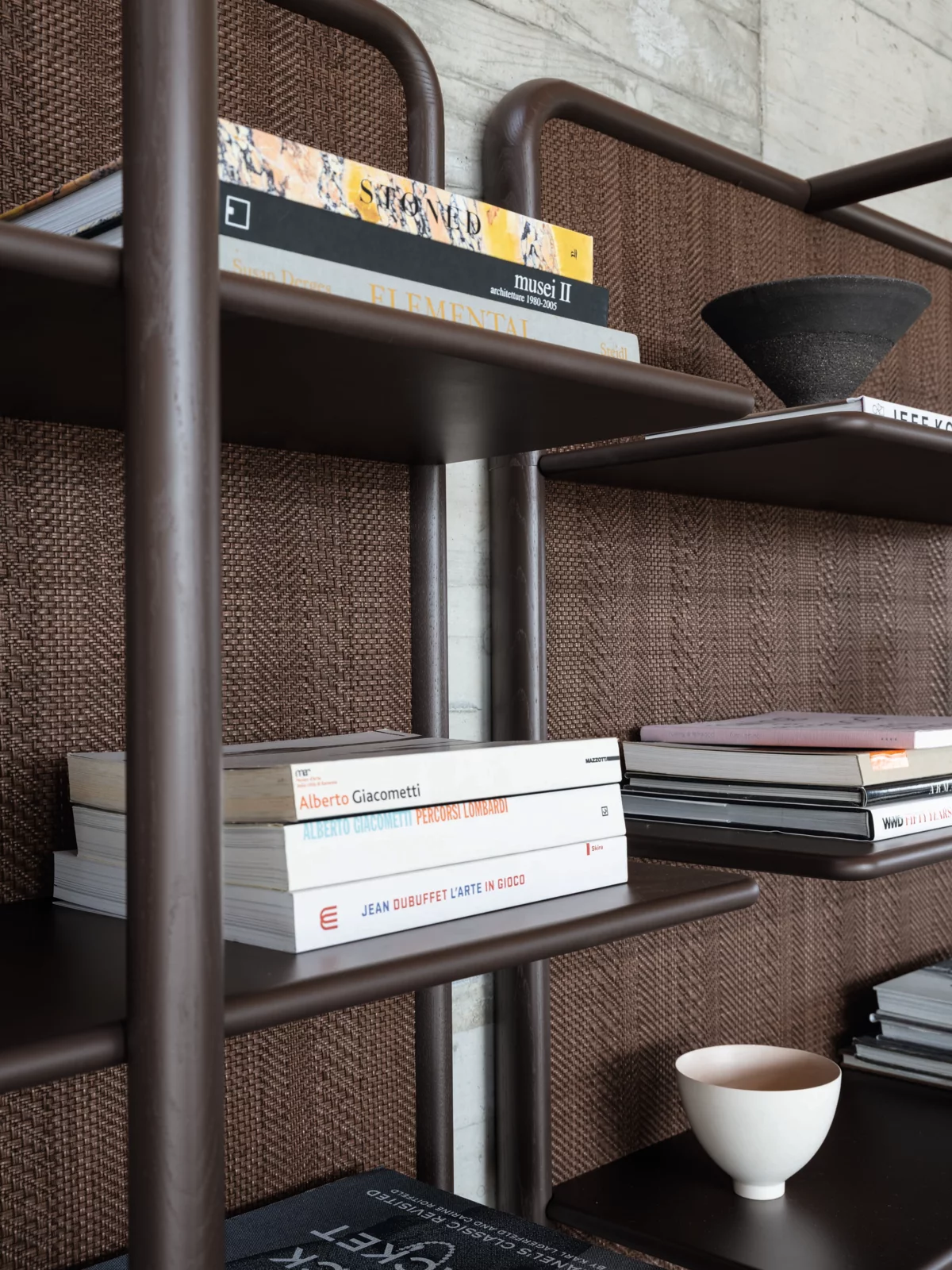 Ein Regal von Gervasoni mit Büchern und Dekorationsgegenständen in einem modernen Wohnzimmer ohne Hintergrund