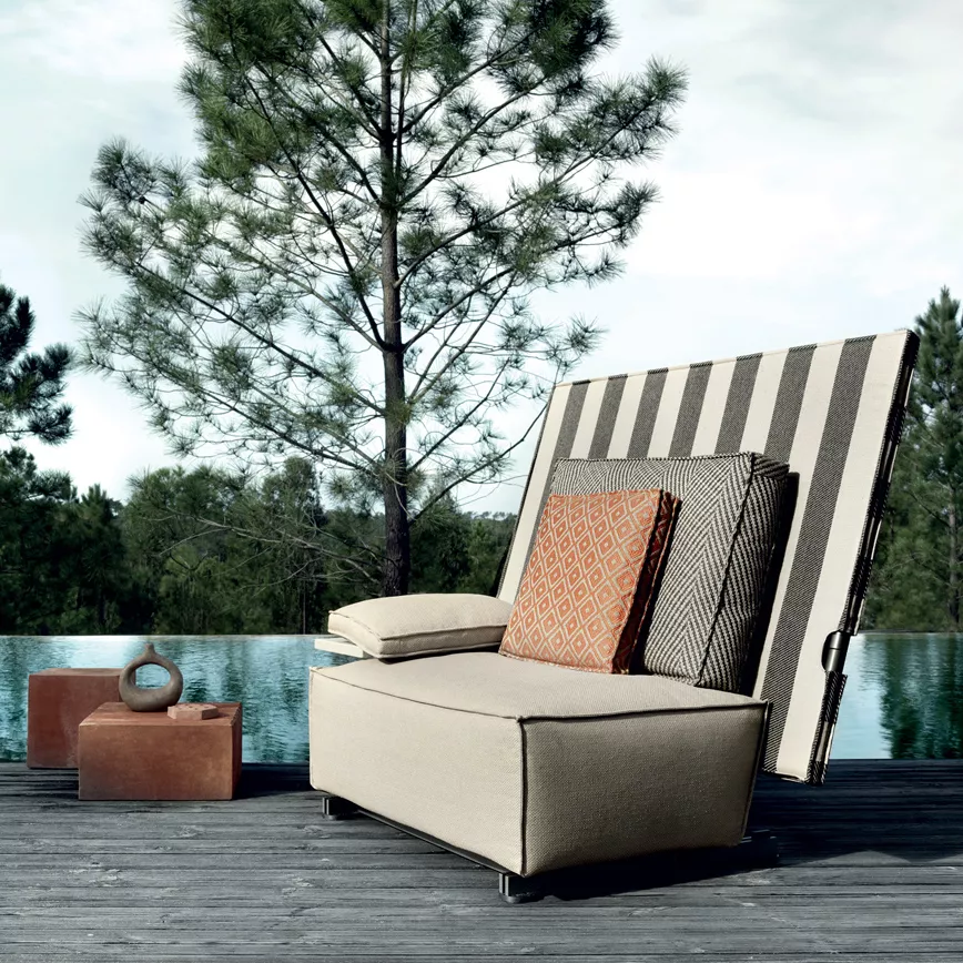 B&B Italia I Oh It Rains Sessel steht auf einer Terrasse vor einem Pool und einem Baum im Hintergrund