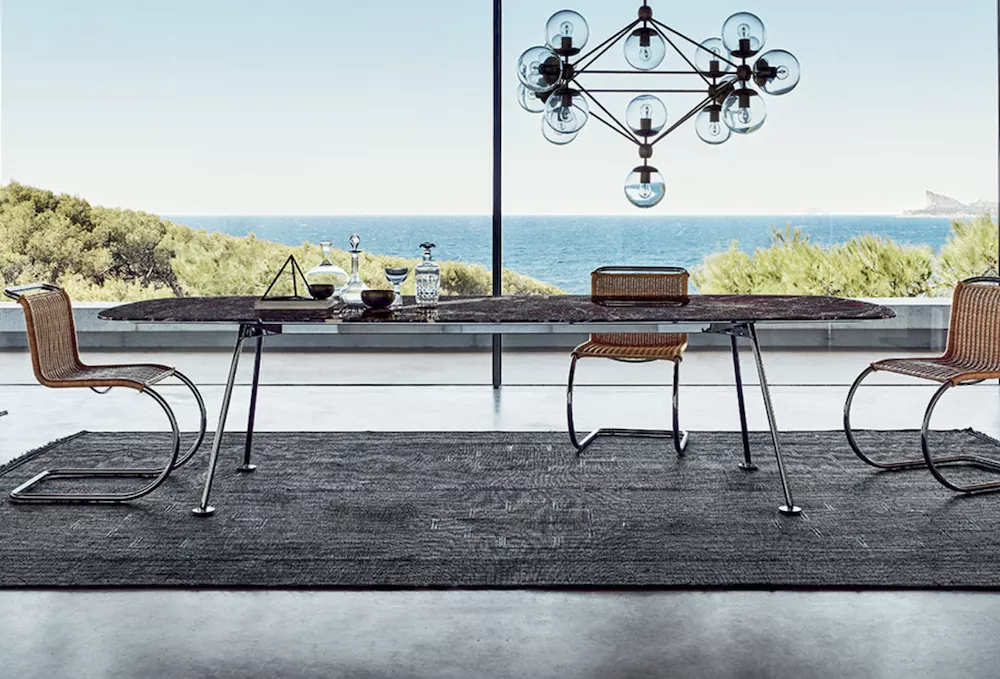 Knoll Grasshopper Tisch in modernem Esszimmer mit Blick auf das Meer und stilvollen Stühlen