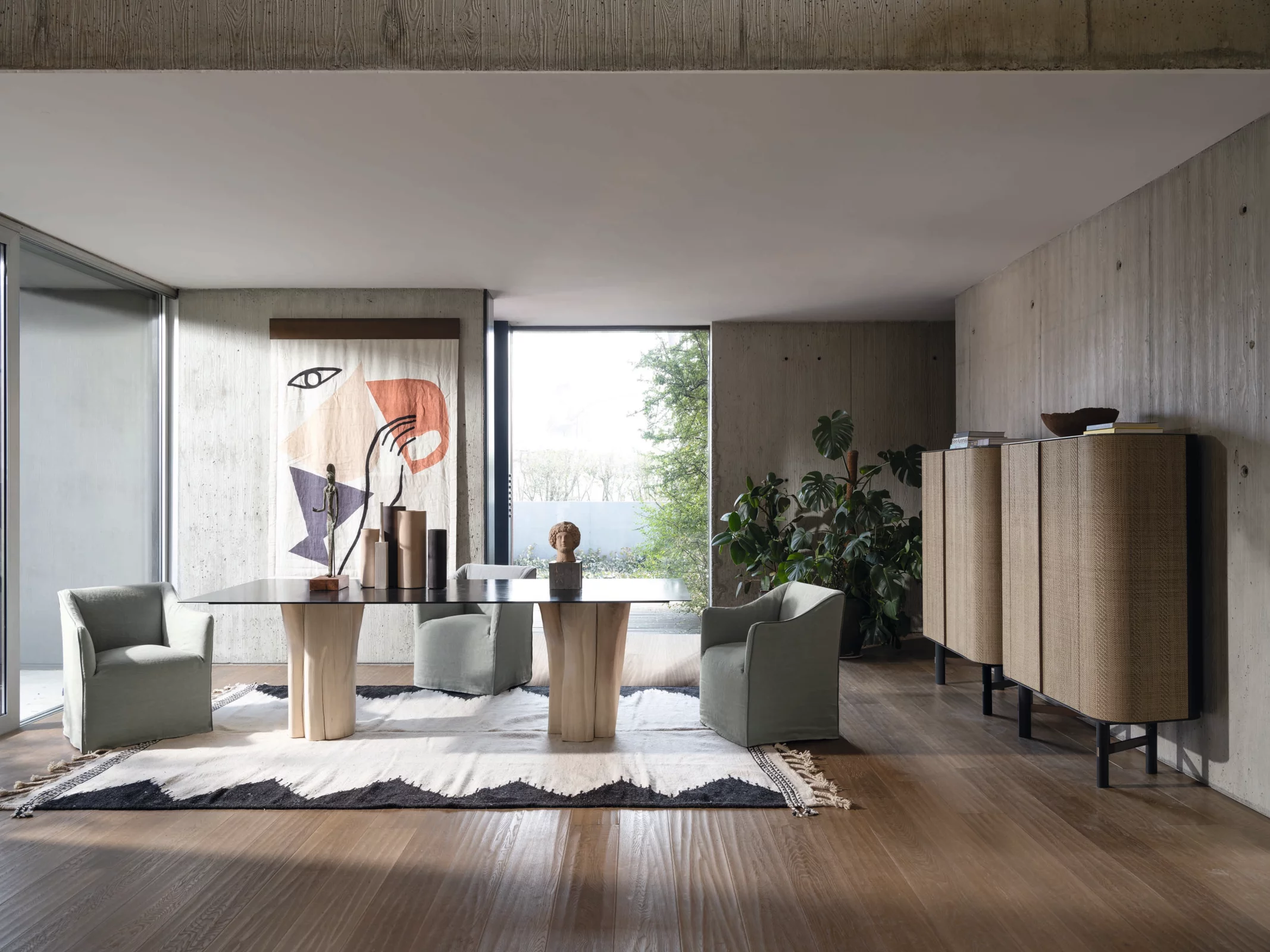 Gervasoni Tisch und Stühle in modernem Wohnzimmer mit Kunstwerk an der Wand und Pflanzen im Hintergrund