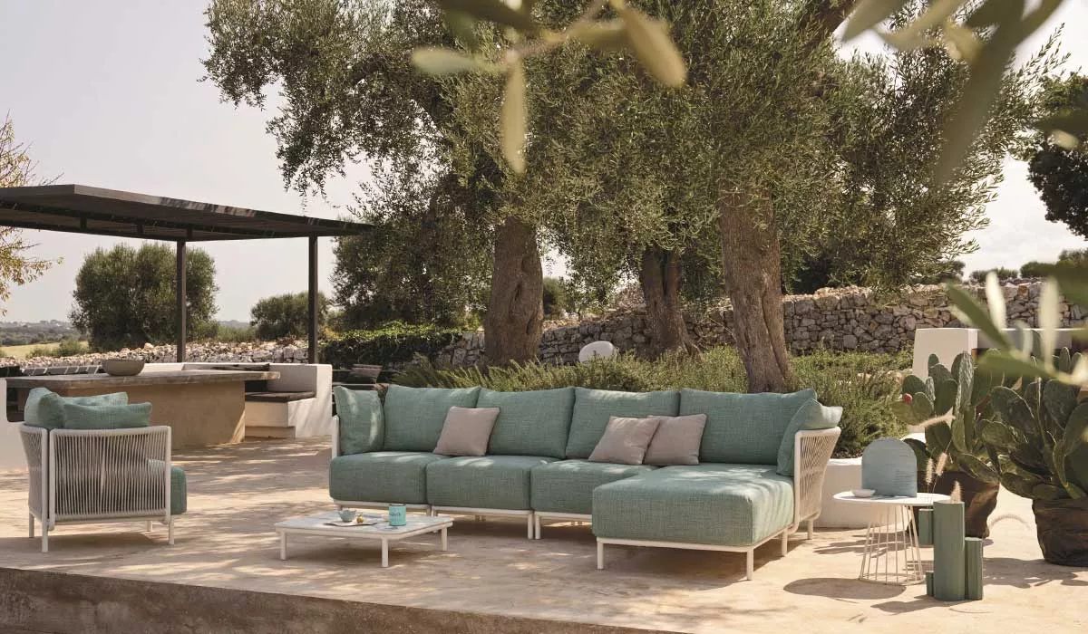 Gartenmöbel-Set Roberti Queen in mintgrün auf einer Terrasse mit Olivenbäumen im Hintergrund, stimmungsvolle Outdoor-Szene.