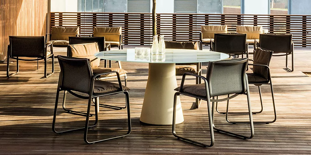 Andreu World Reserve Stühle und Tisch in modernem Design auf einer Holzterrasse bei Tageslicht.