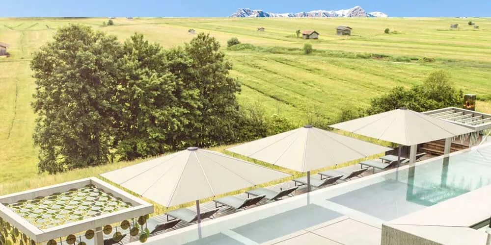 Glatz Palazzo Royal Sonnenschirme in Beige neben einem Pool mit Blick auf eine weite, grüne Landschaft und Berge im Hintergrund.