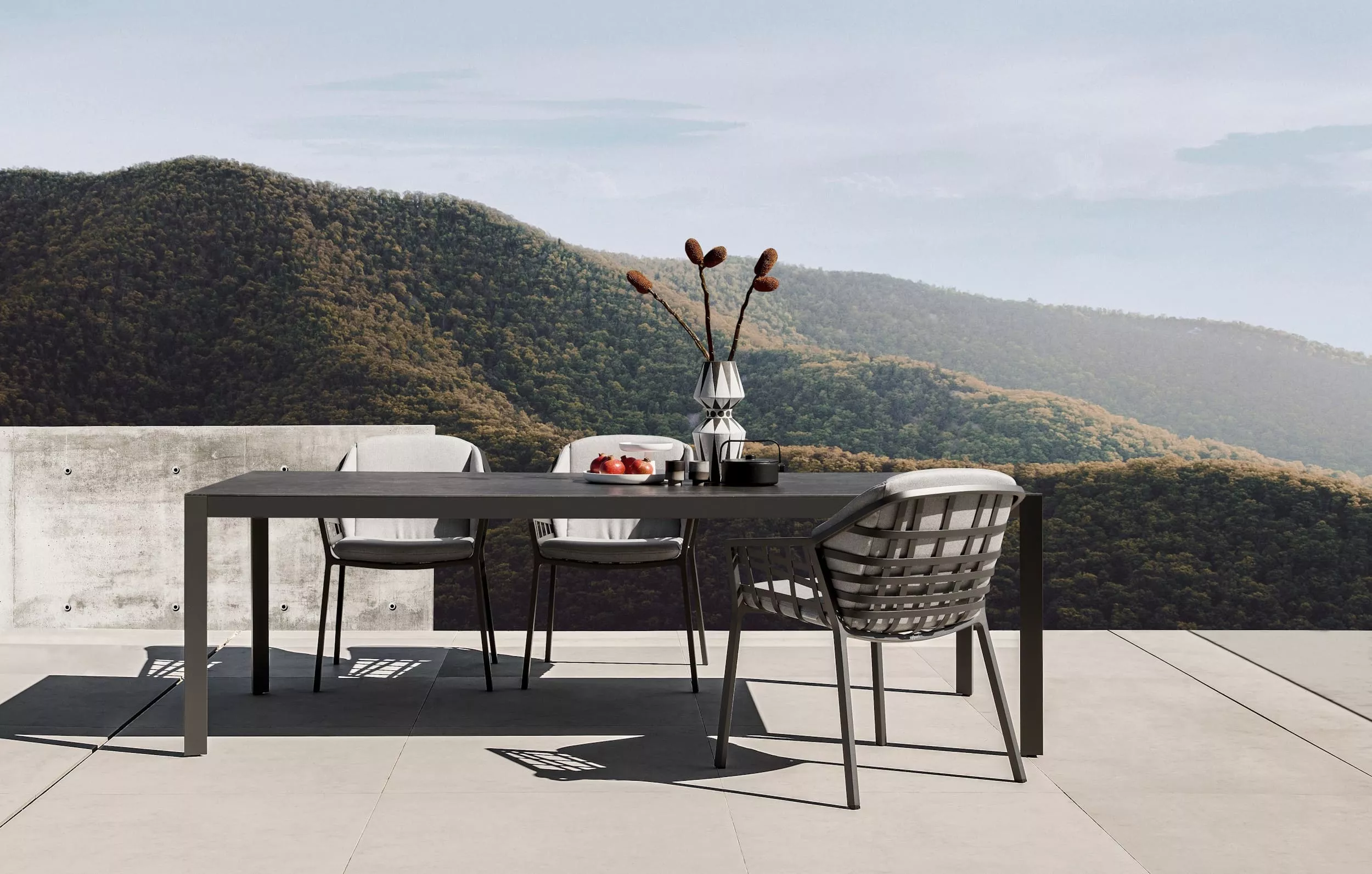 Solpuri Classic Alu Tisch und Stühle auf einer Terrasse mit Bergblick und gedecktem Tisch mit Vase und Obstkorb Moodbild