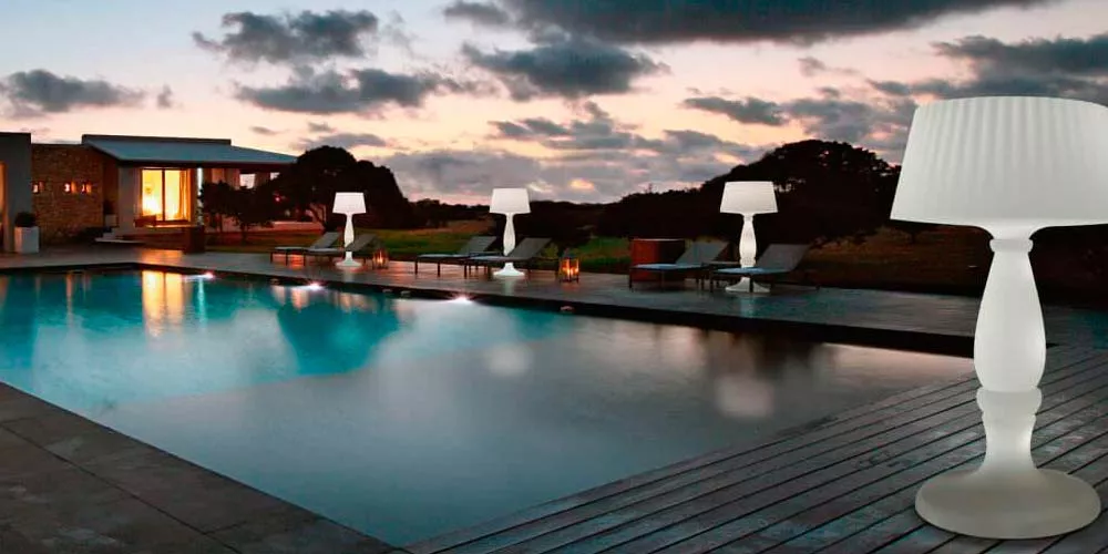 Weiße Myyour Agata Leuchten am Pool bei Sonnenuntergang, stimmungsvolle Außenbeleuchtung auf Holzterrasse.