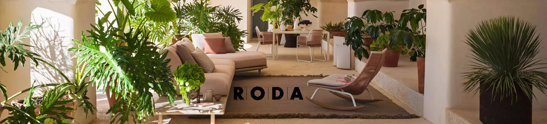 RODA Outdoor-Möbel in einem mediterranen Innenhof mit beigen Sofas, grünen Pflanzen und einem entspannten Ambiente.