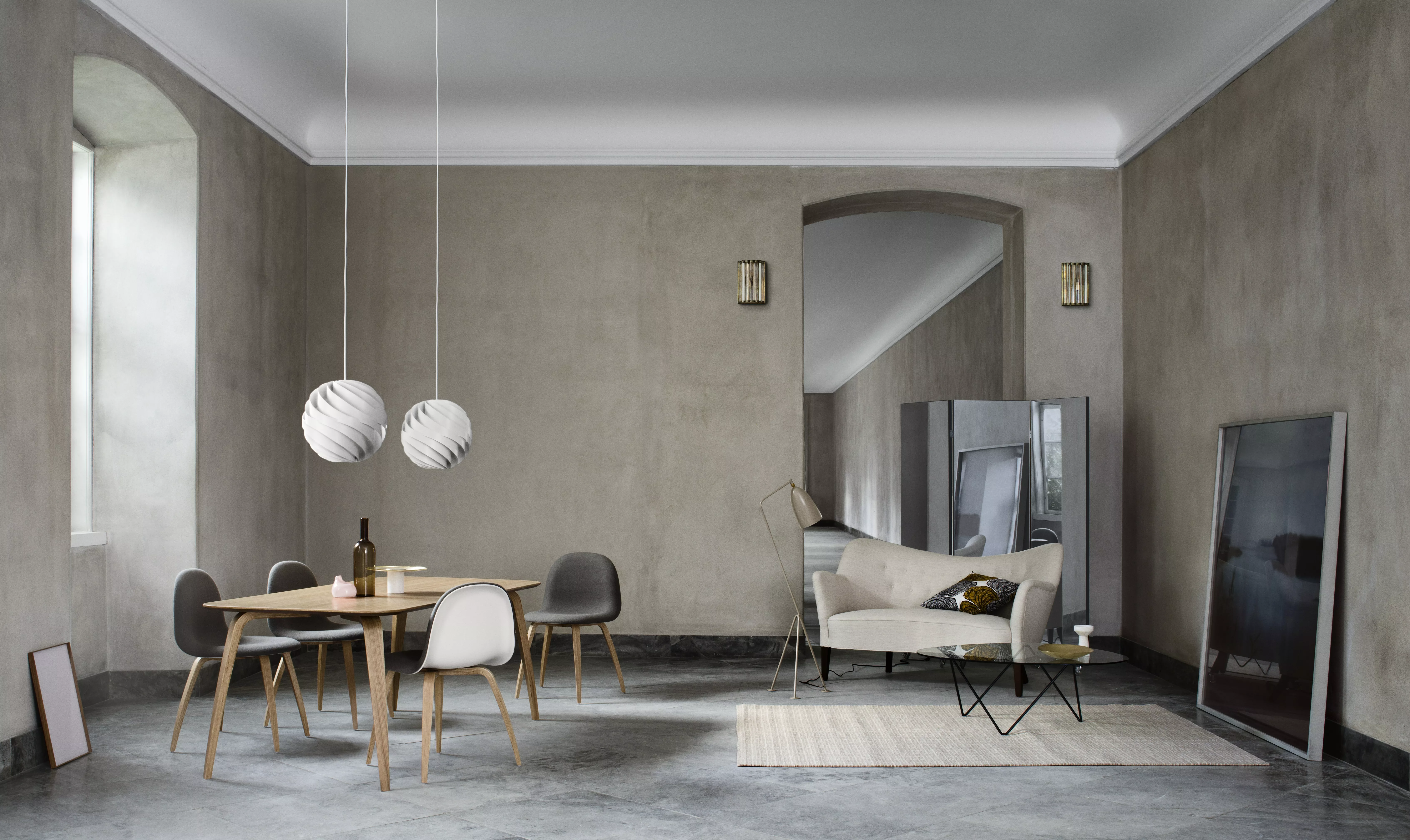 Ein stilvoll eingerichtetes Wohnzimmer mit GUBI Dining Table Rectangular und 3D Dining Chair sowie Turbo Pendant und Grashoppa Floor Lamp in einer gemütlichen Atmosphäre.
