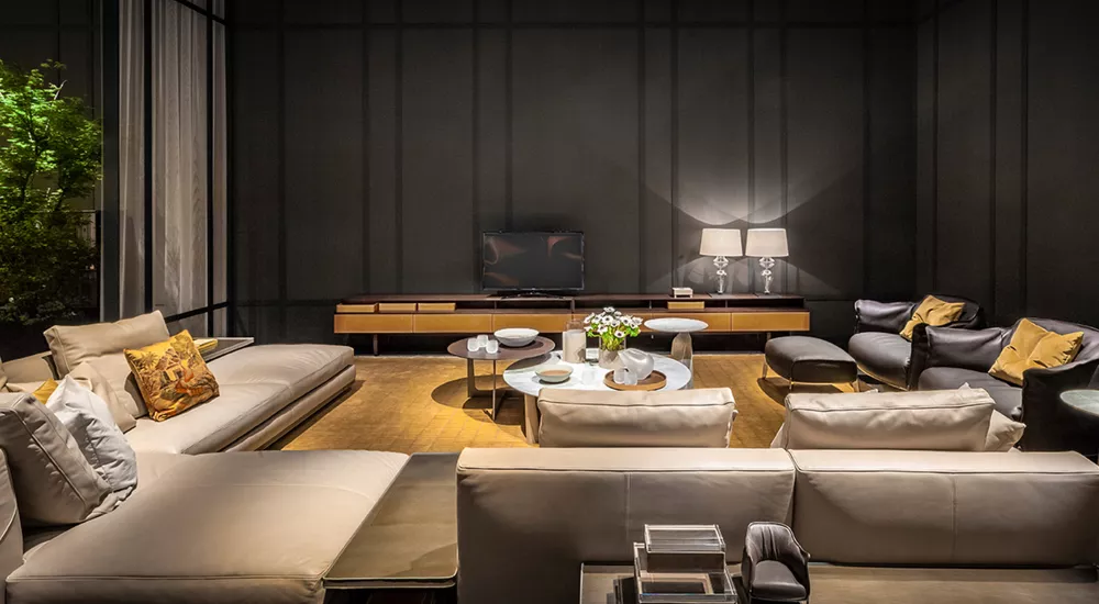 Wohnzimmer mit Poltrona Frau Fidelio Möbeln in neutralen Tönen, stimmungsvolle Beleuchtung und moderne Dekoration auf Holzboden.