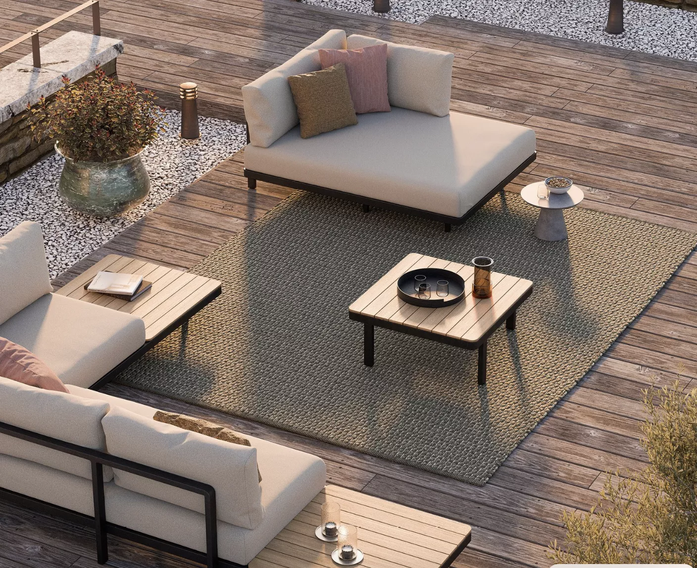 Royal Botania Loungegruppe in Beige auf Holzterrasse mit Kissen und Beistelltisch, stimmungsvolle Abendsonne im Hintergrund.