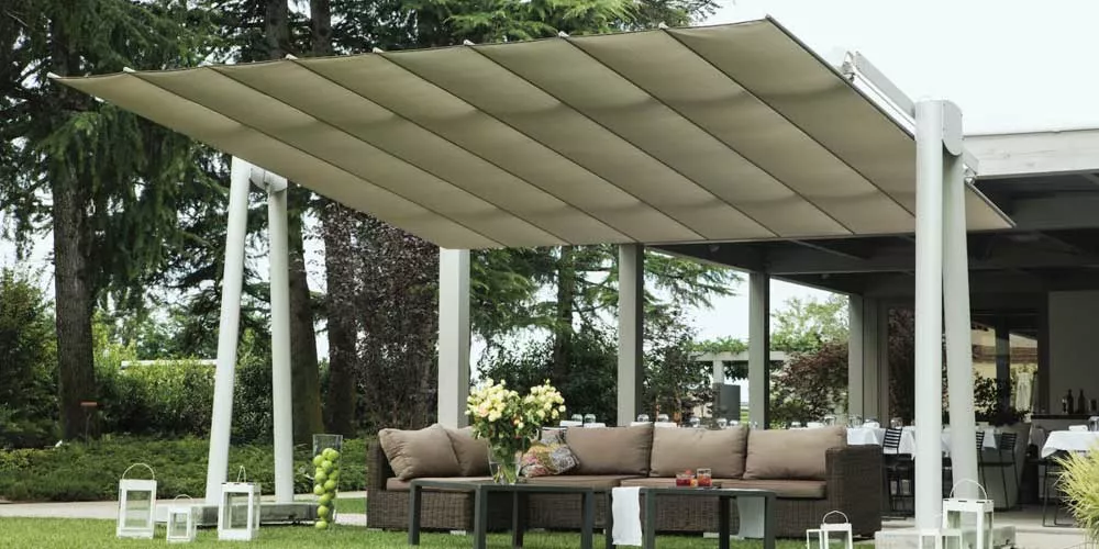 FIM Flexy XL Sonnenschirm in Beige über einer modernen Terrassenlounge mit grüner Gartenkulisse.