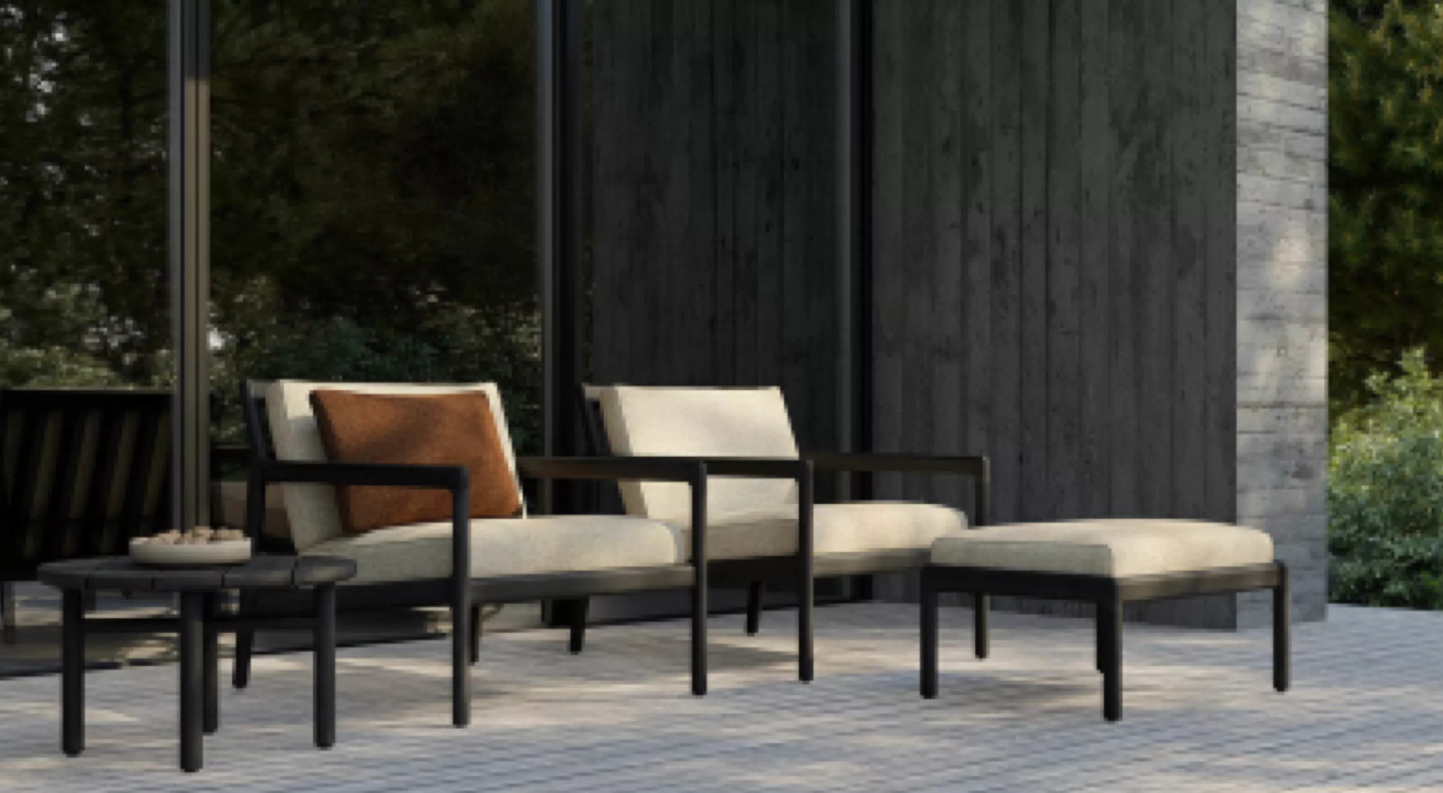 Gartenmöbel-Set von Villa Schmidt mit schwarzem Gestell und beigen Kissen auf einer Terrasse vor einer modernen Glasfassade.