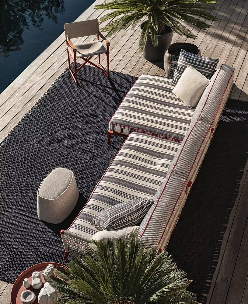 B&B Italia Ribes Outdoor Lounge auf einer Terrasse neben einem Pool mit Pflanzen und einem Beistelltisch im Freien