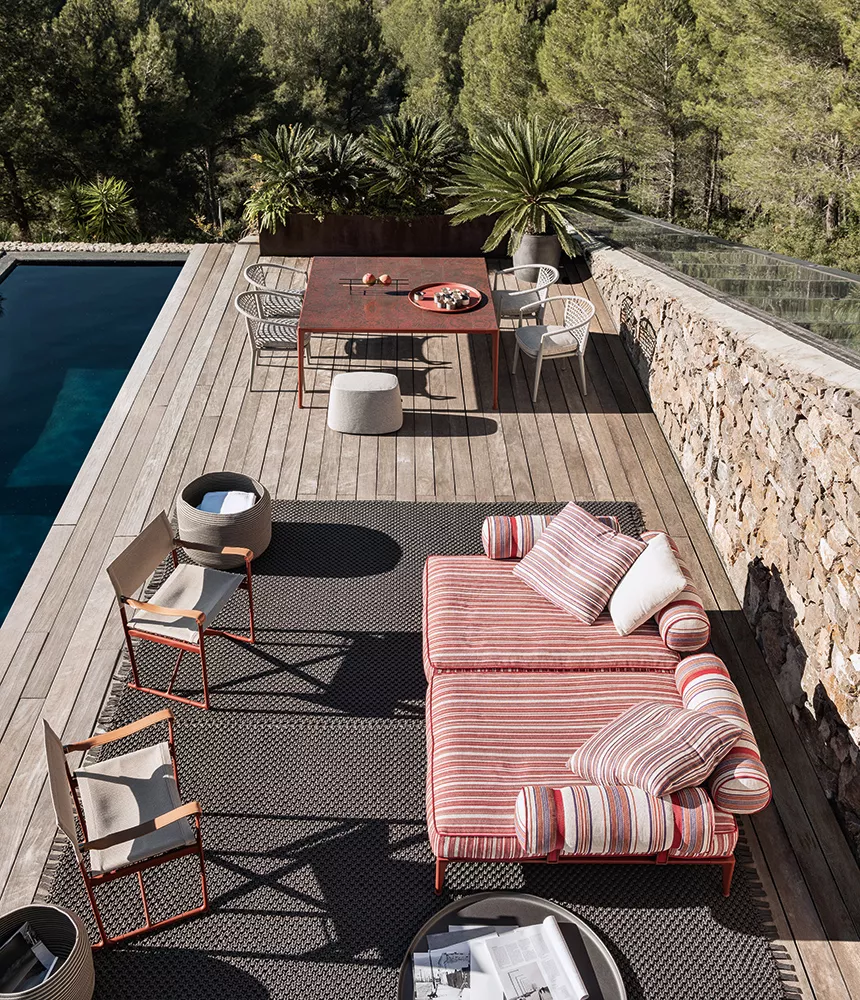 B&B Italia Ribes Outdoor Lounge auf einer Terrasse mit Pool und Wald im Hintergrund