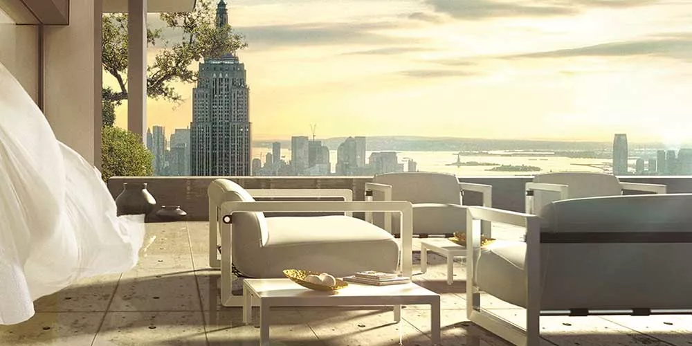 Mayface Saccu Loungegruppe Gartenmöbel in Weiß auf einer Terrasse mit Stadtblick bei Sonnenuntergang, stimmungsvolles Ambiente.