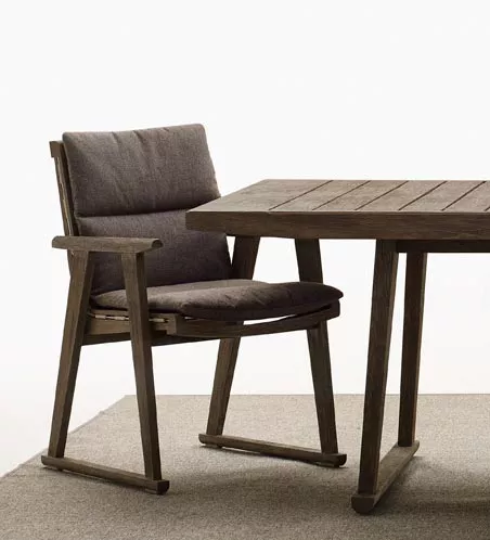 B&B Italia Gio Gartentisch 220 cm und Stuhl aus Holz mit Polsterung auf einem Teppich ohne Hintergrund