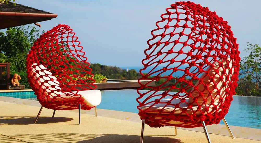 Kenneth Cobonpue Dragnet Loungegruppe in Rot, am Pool mit Blick auf die Landschaft, zeigt modernes Design und Komfort.