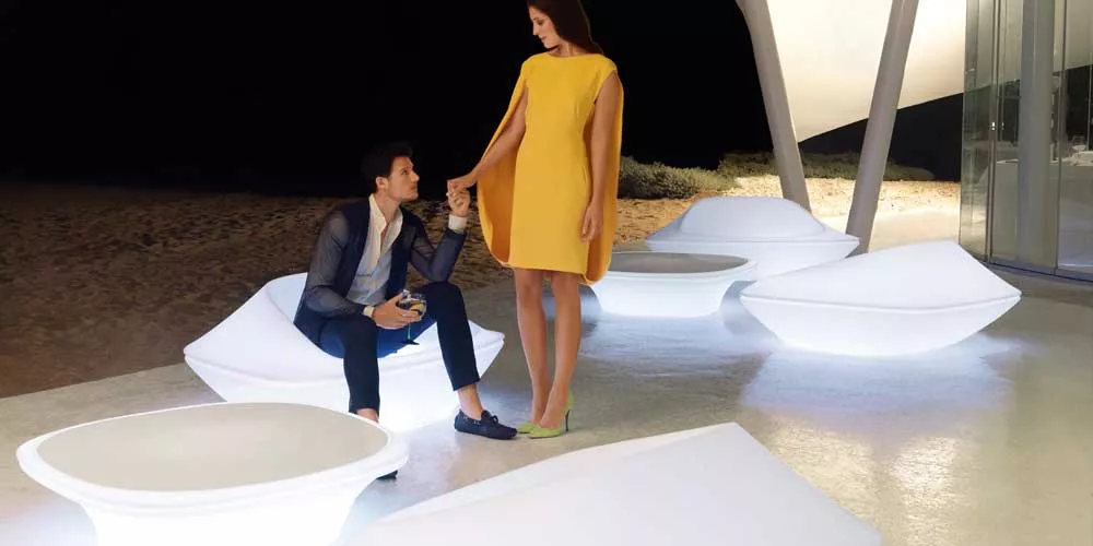 Vondom UFO Loungegruppe in Weiß, stimmungsvolle Abendaufnahme am Strand mit elegantem Paar, moderne Gartenmöbel im futuristischen Design.