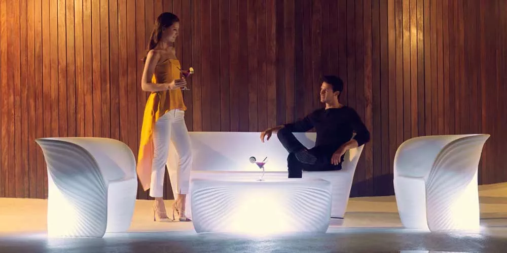 Vondom Biophilia Loungegruppe in Weiß, bestehend aus Sofa und Sesseln, auf einer Terrasse mit Holzverkleidung im Hintergrund.