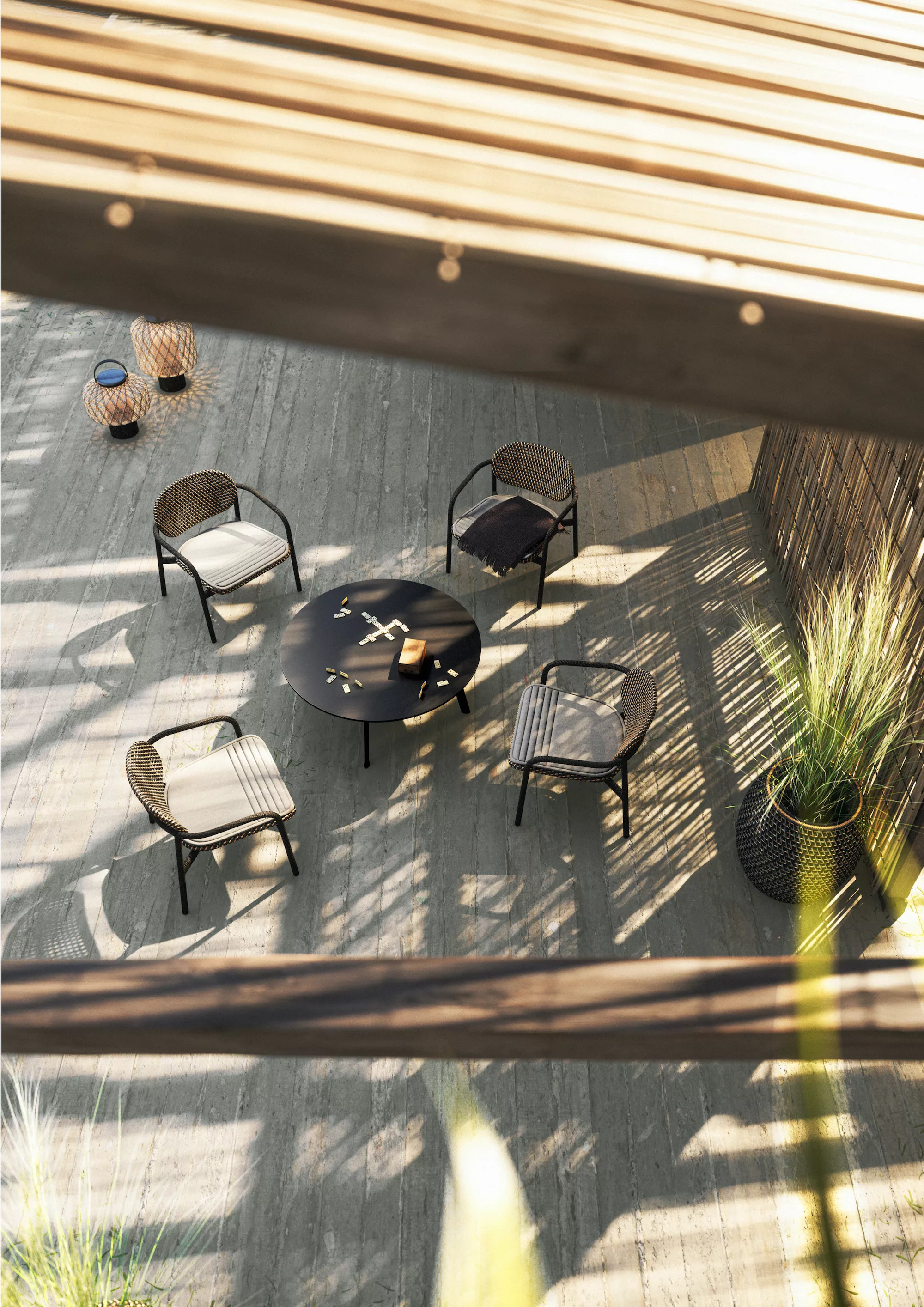 Dedon Roidin Stühle und Tisch in einem stilvollen Außenbereich mit Holzboden und Bambuswand bei Sonnenlicht und Schatten.