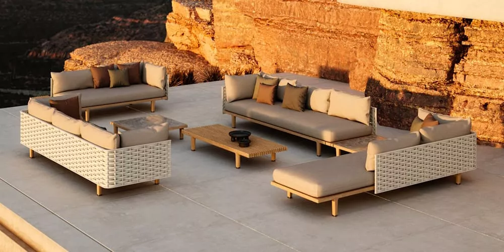 VS Loungegruppe in Beige und Weiß auf einer Terrasse mit Felskulisse bei Sonnenuntergang, bestehend aus Sofas und einem Couchtisch.