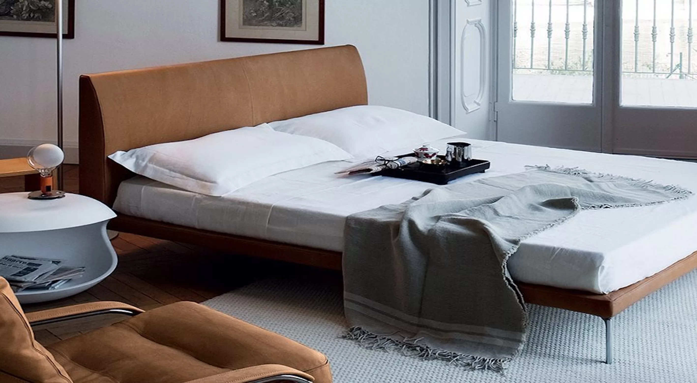 Talamo Bett von Poltrona Frau in Cognac-Leder, in einem modernen Schlafzimmer mit Tageslicht und stilvoller Dekoration.