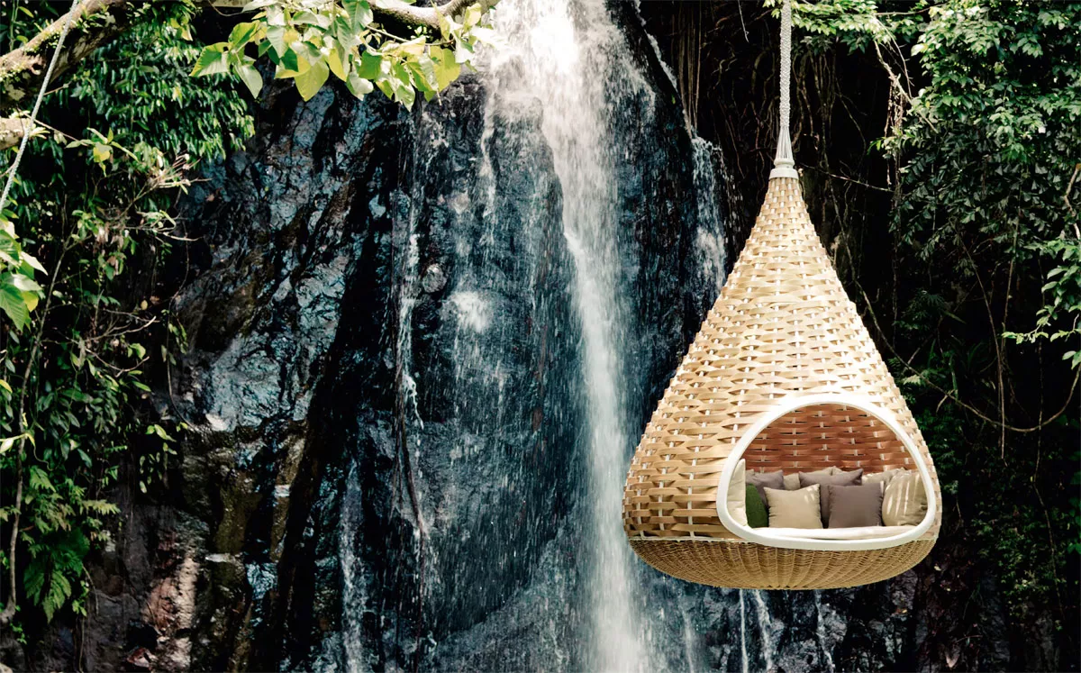 Nestrest Hanging Lounger rund 200 cm von Dedon hängt vor einem Wasserfall in einem dichten Wald und bietet eine entspannende Atmosphäre
